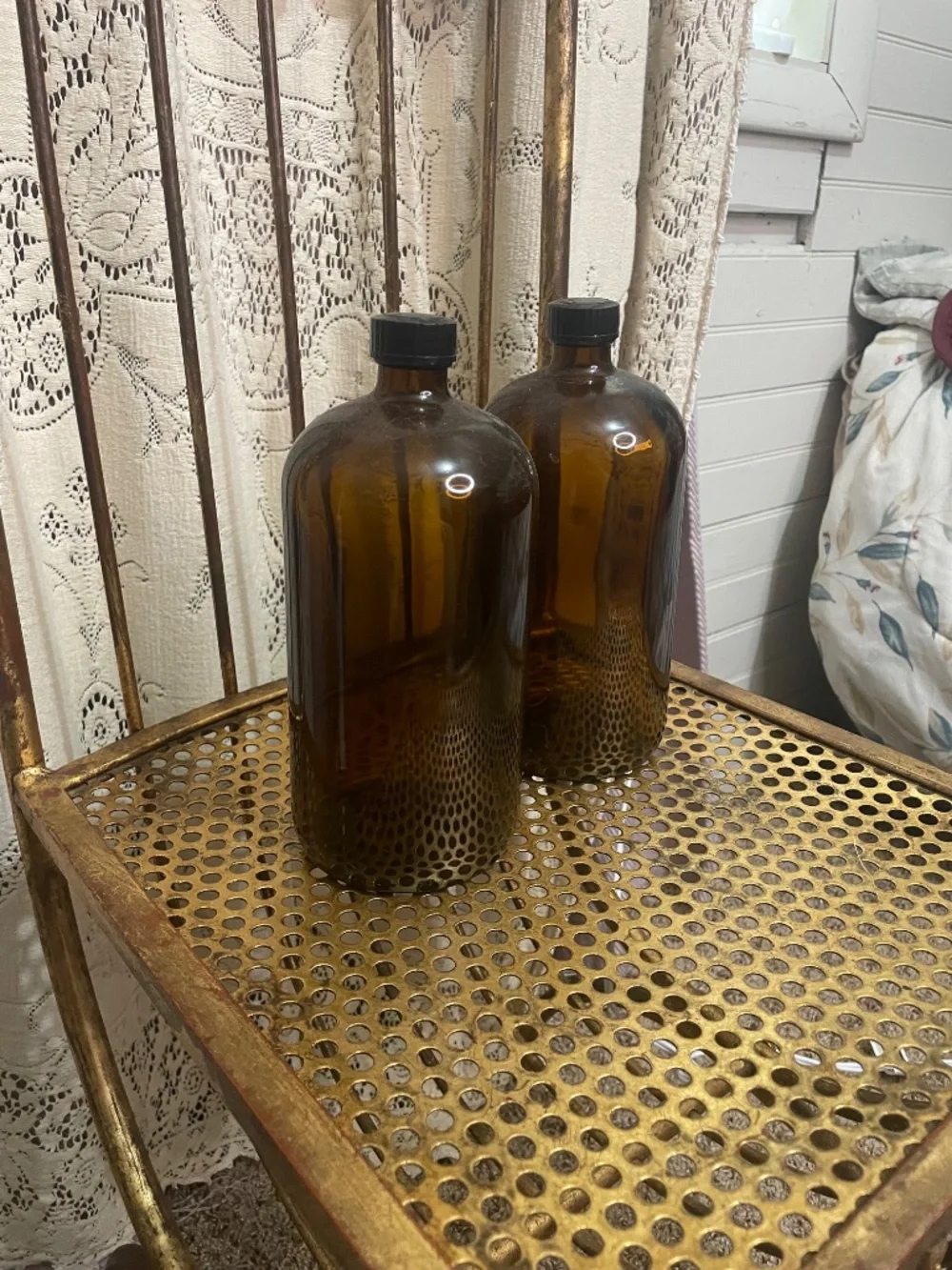 two amber glass Boston round bottles with black caps